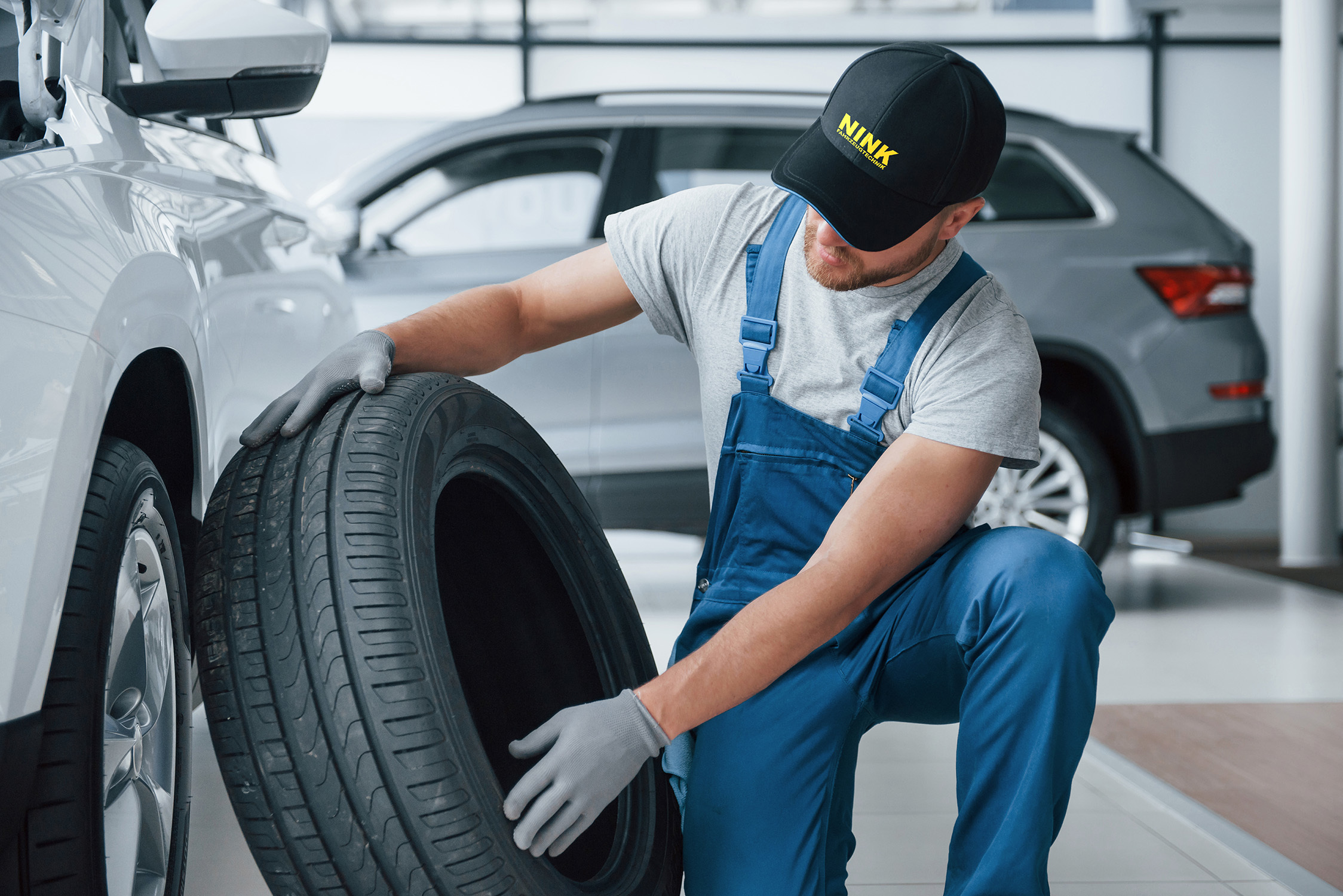 Mechaniker bei Fahrzeugtechnik Nink prüft einen Reifen für einen Frühlingscheck, der eine umfassende Fahrzeugbetreuung für Mercedes-Benz und andere Marken bietet.